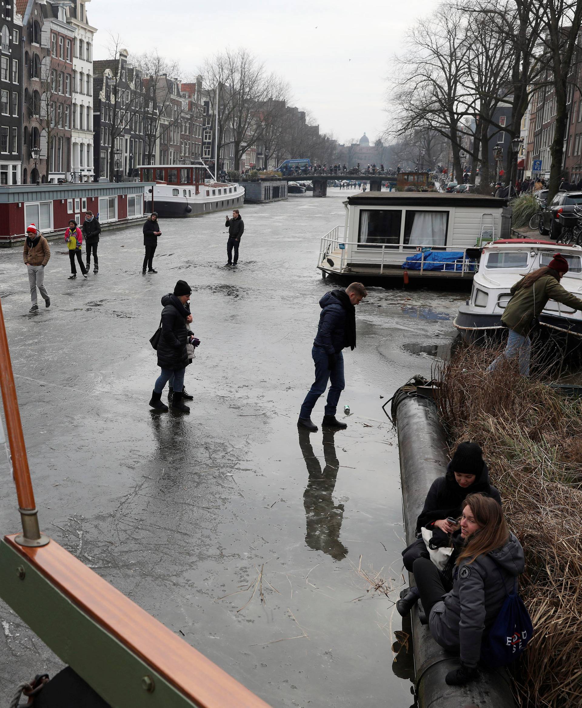 Ice skaters skate on the frozen Prinsengracht canal during icy weather in Amsterdam