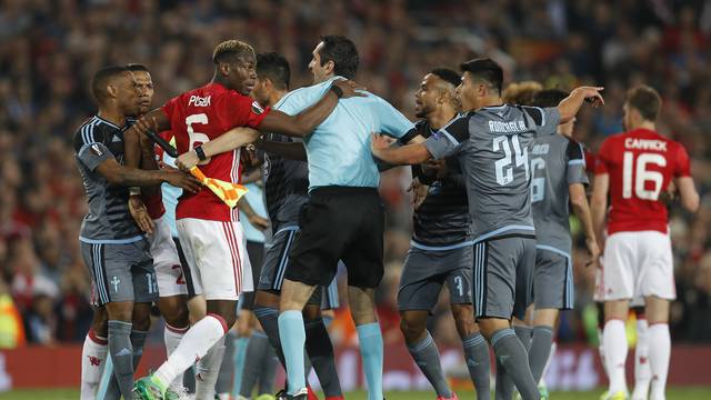 Manchester United's Paul Pogba clashes with Celta Vigo's Facundo Roncaglia as referee Ovidiu Hategan intervenes