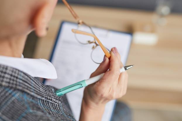 Female Psychologist Writing on Clipboard Closeup