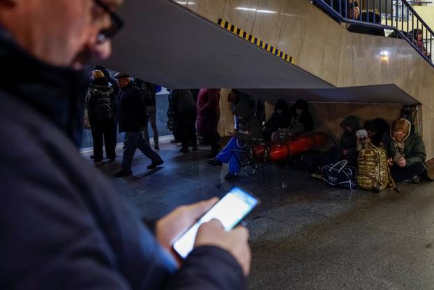 People take shelter inside a metro station during a Russian military attack, in Kyiv