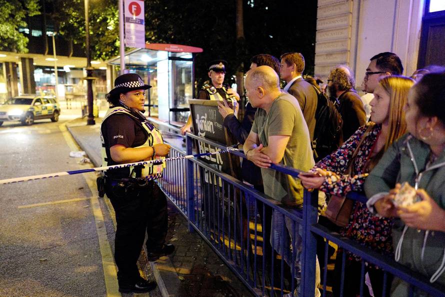 Police and commuters are seen outside Euston Station after police evacuated the area following a security alert in London