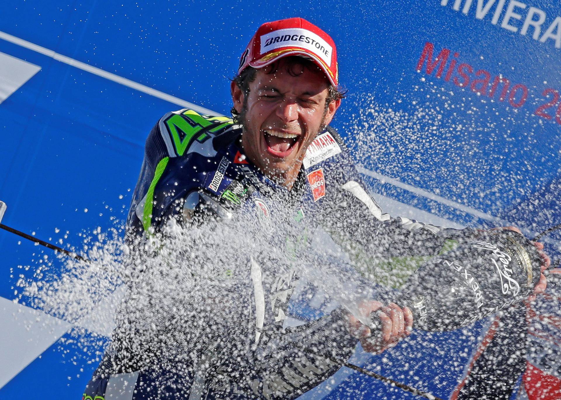 FILE PHOTO: Yamaha MotoGP rider Rossi of Italy sprays champagne on the podium after winning the San Marino Grand Prix in Misano Adriatico circuit in central Italy