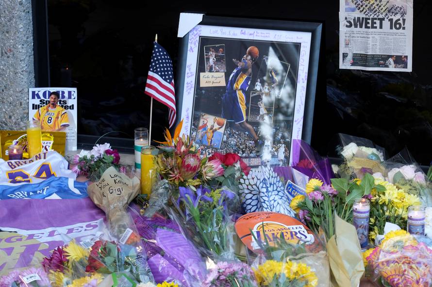 Flowers, photos and messages are placed at a makeshift memorial for former NBA player Kobe Bryant outside of the Mamba Sports Academy in Thousand Oaks