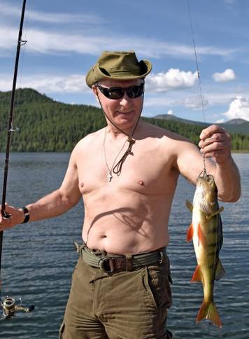 Russian President Vladimir Putin holds a fish he caught during the hunting and fishing trip which took place on August 1-3 in the republic of Tyva in southern Siberia