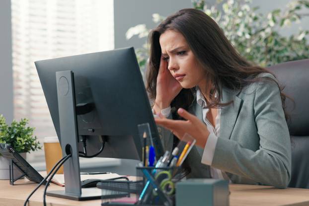 Beautiful,Busy,Businesswoman,Sits,At,Desk,In,Front,Of,Computer