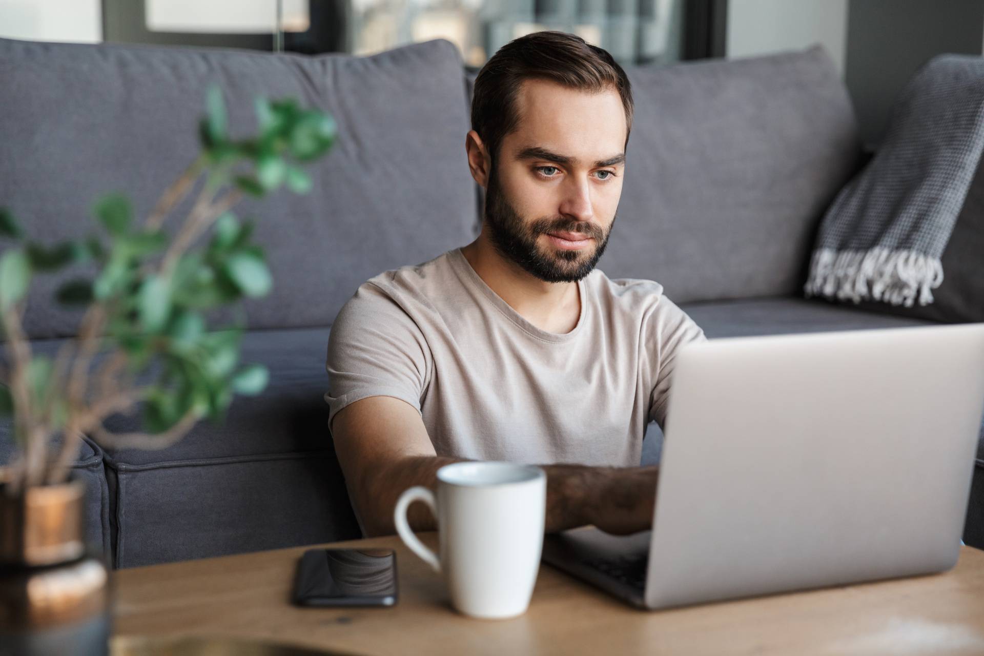 Concentrated young man using laptop computer.