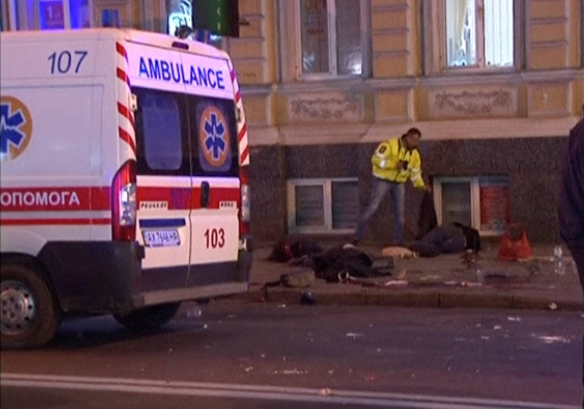 A still image taken from a video shot on October 18, 2017, shows bodies laying on the ground next to an ambulance at the accident scene after a car drove into pedestrians following a vehicle collision in central Kharkiv