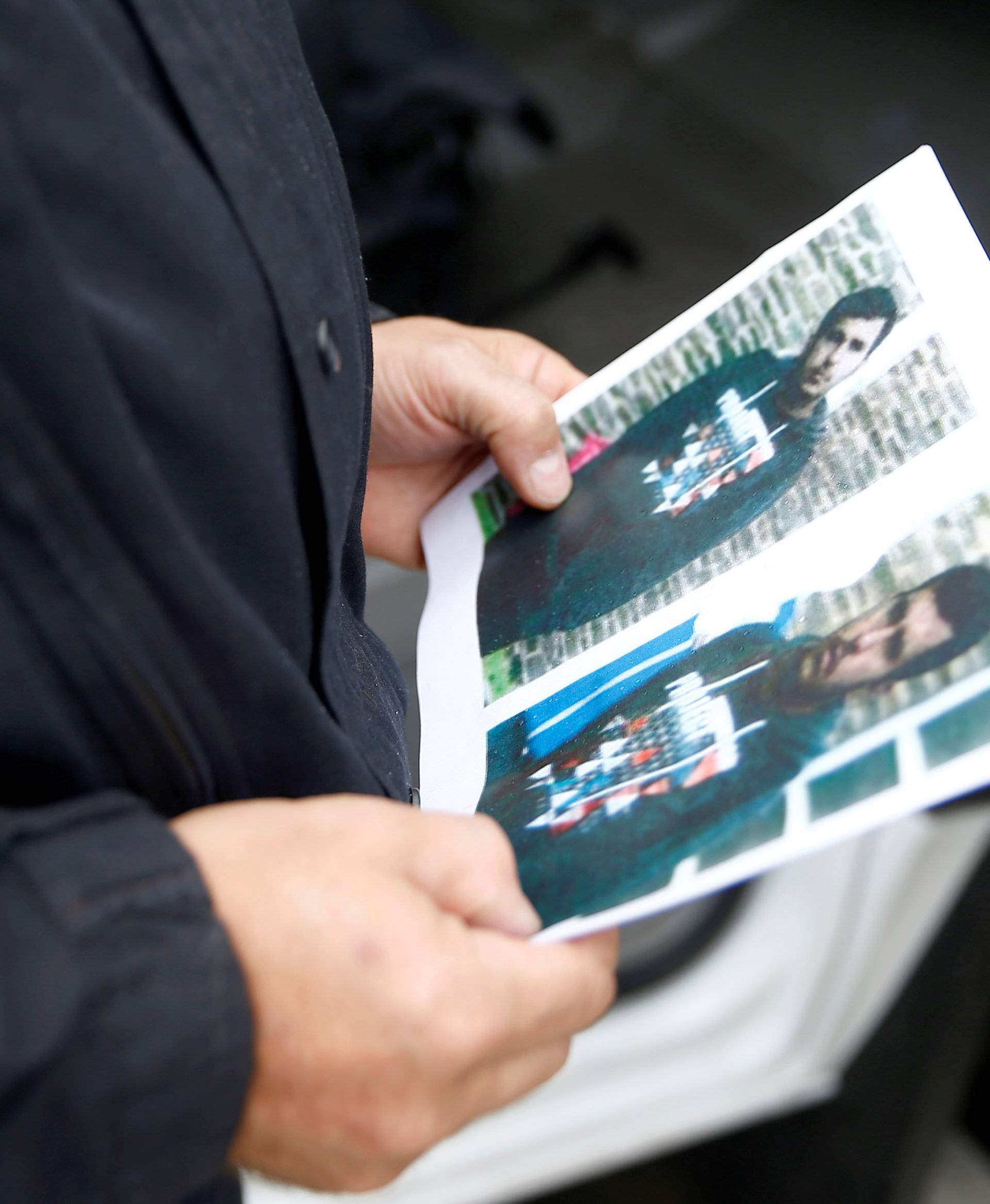 A German policeman holds the picture of a terrorist-subject infront of the main terminal of Berlin-Schoenefeld airport, in Schoenefeld