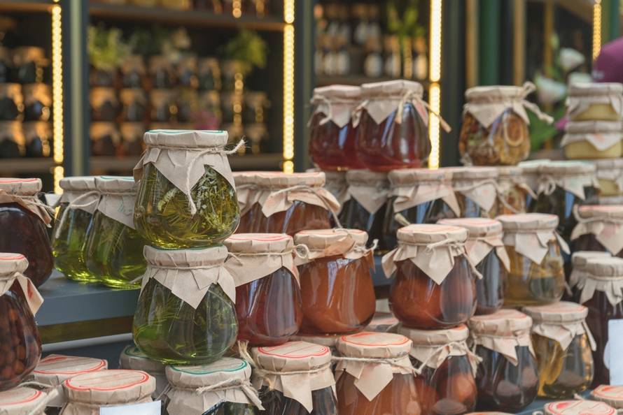 Market,Stall,Displaying,A,Bunch,Of,Stacked,Colorful,Glass,Jars