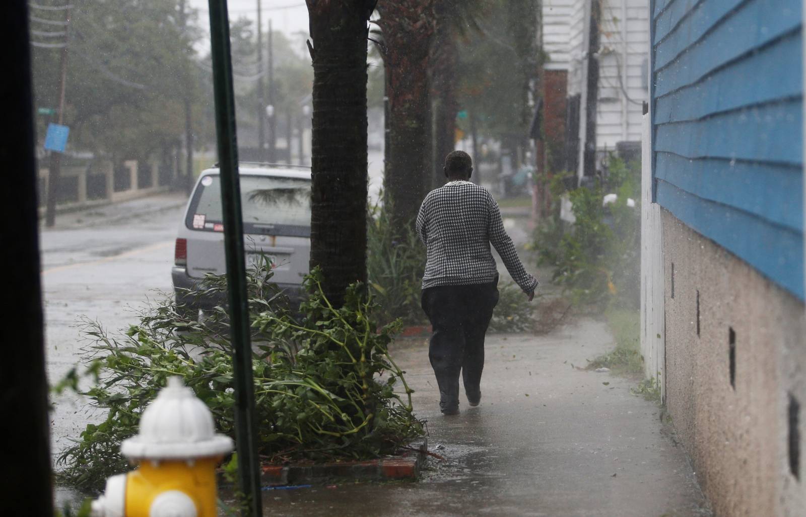 A woman walks down a street during Hurricane Dorian in Charleston