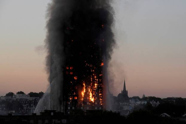FILE PHOTO: Flames and smoke billow as firefighters deal with a fire in the Grenfell Tower apartment block in West London, Britain