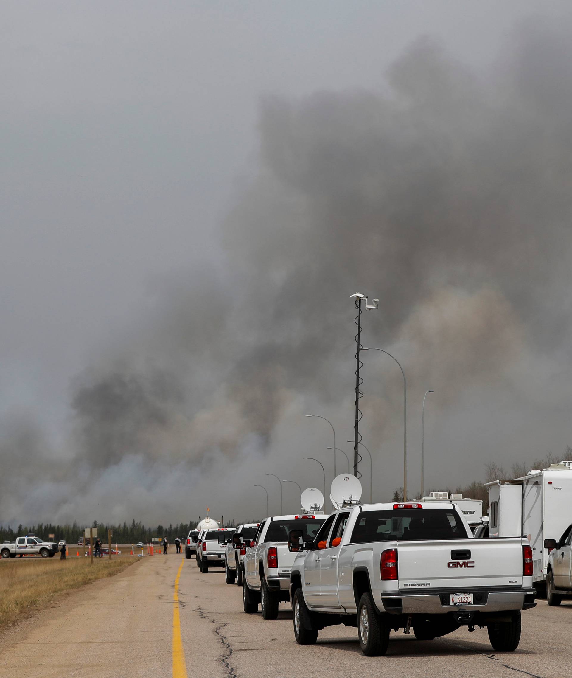 Ontario firefighters in pickup trucks drive into wildfires near Fort McMurray