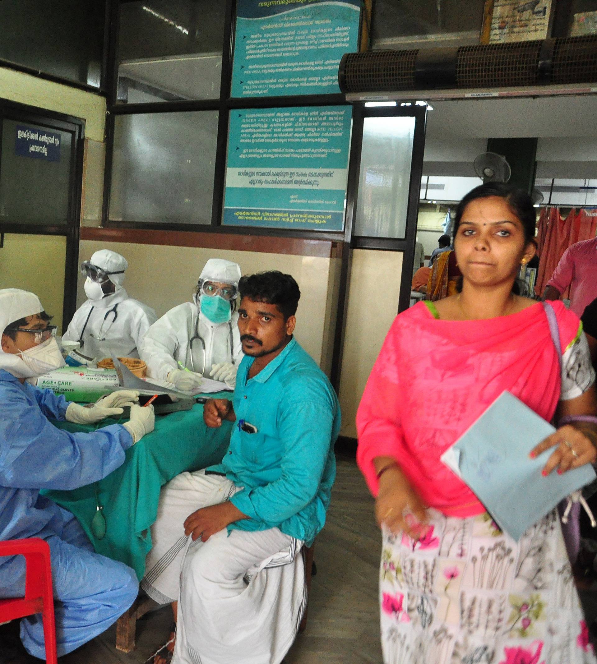 Medics wearing protective gear examine a patient at a hospital in Kozhikode in the southern state of Kerala