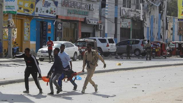 An injured civilian is evacuated from the scene of an explosion near the education ministry building along K5 street in Mogadishu