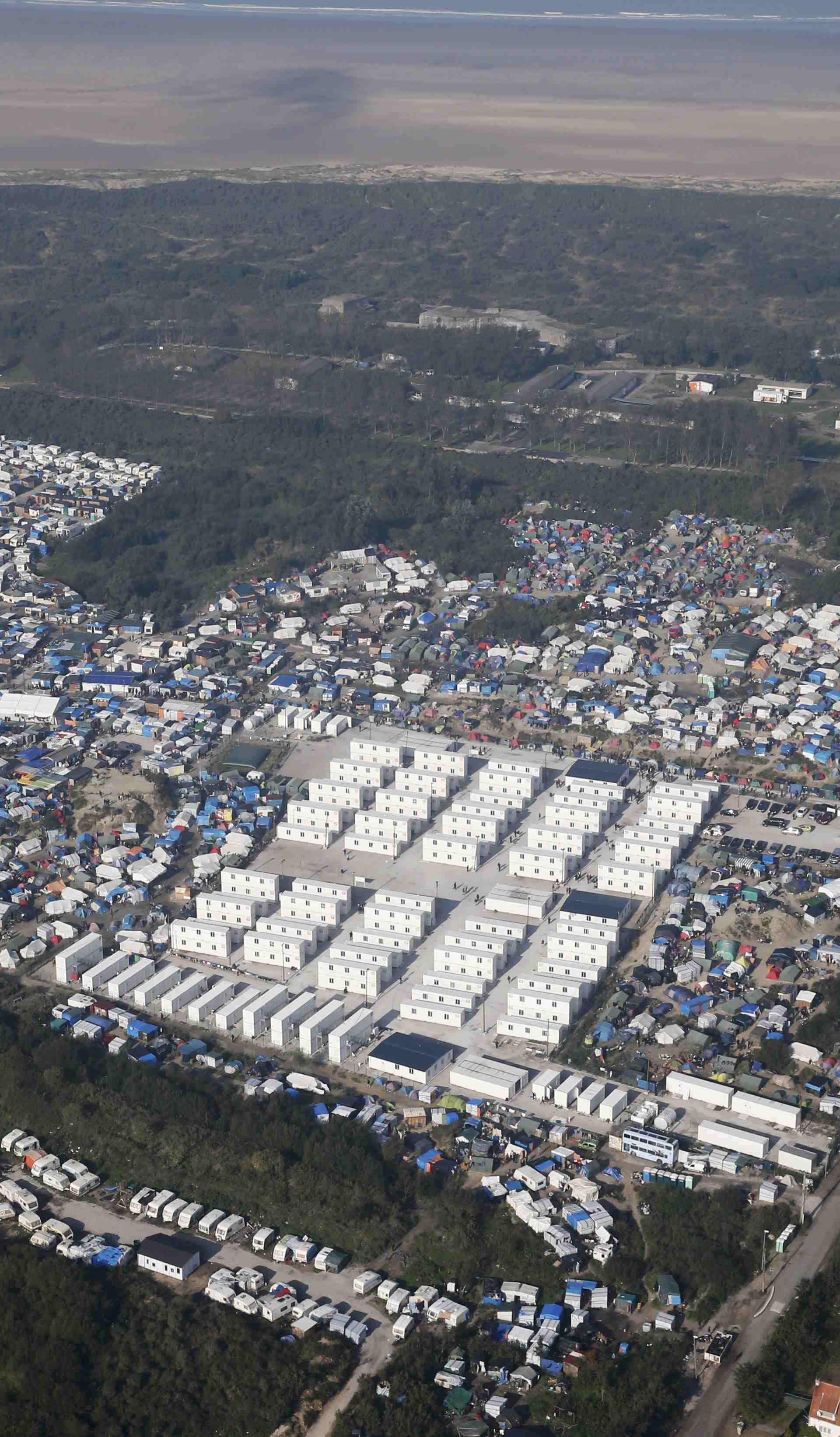 An aerial view shows white containters, tents and makeshift shelters on the eve of the evacuation and dismantlement of the camp called the "Jungle" in Calais