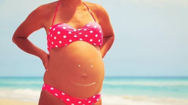 Happy pregnant woman at beach