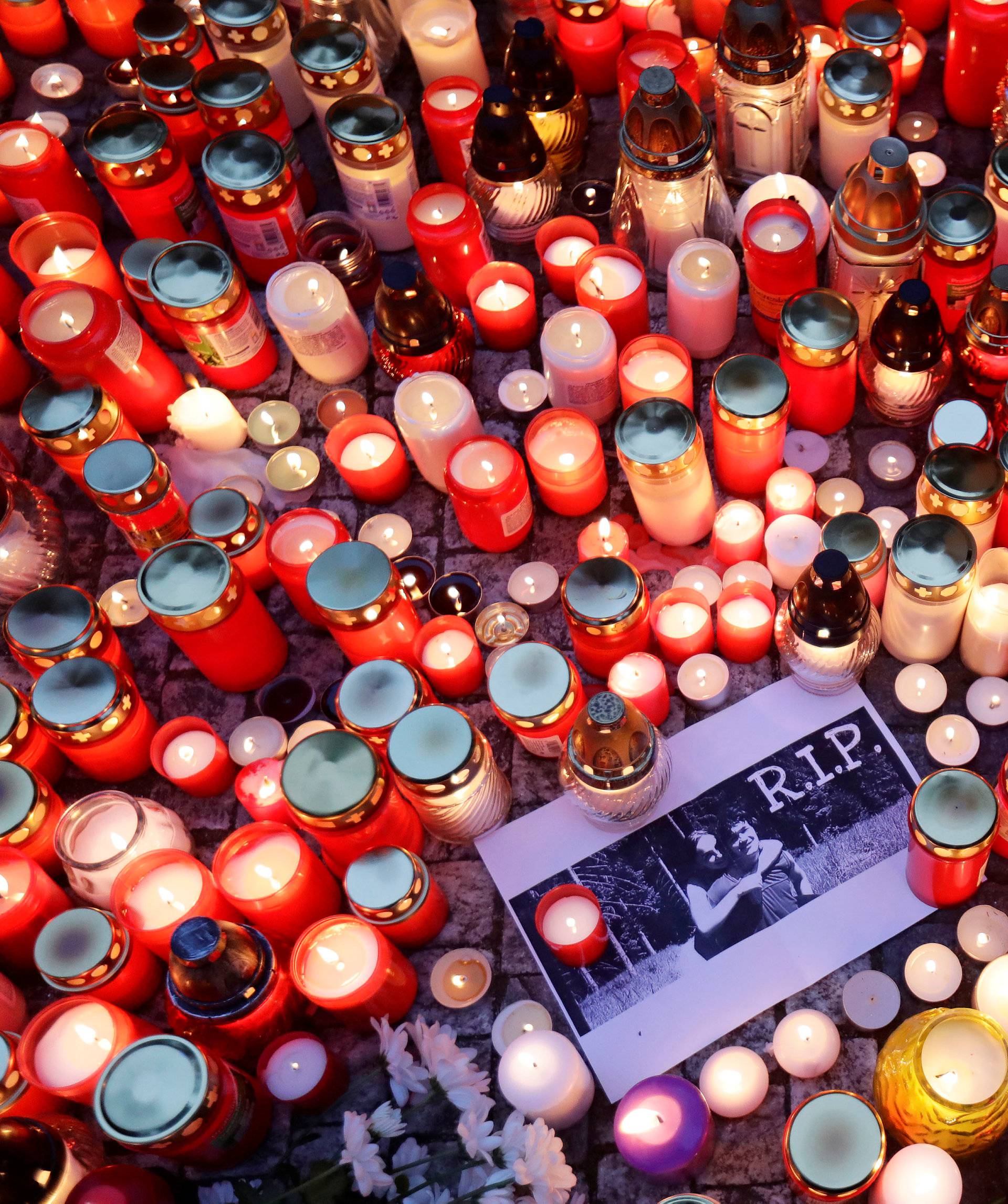 A woman places a candle in memory of killed investigative reporter Jan Kuciak in front of the Slovak embassy in Prague