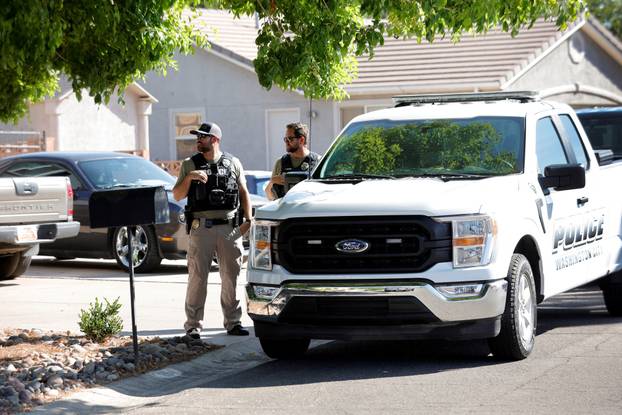 Law enforcement officials investigate at a residence in Washington