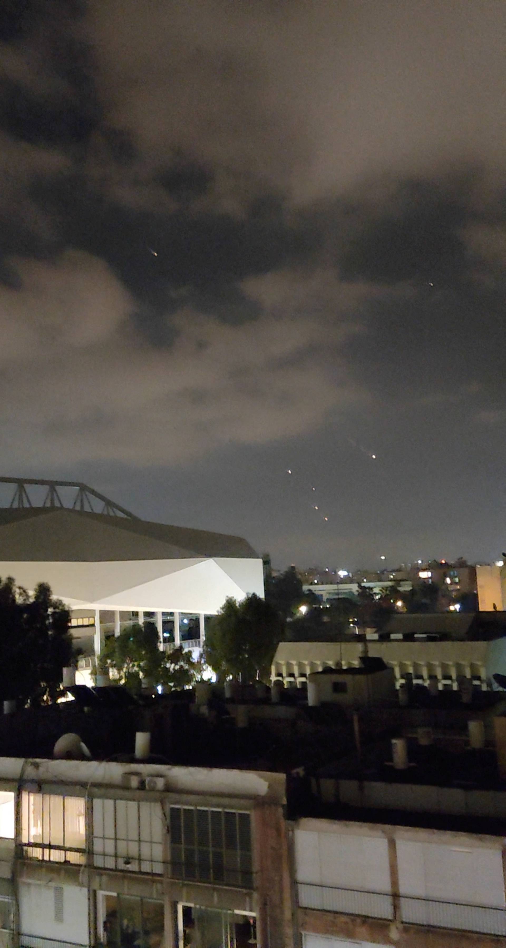 Objects are seen in the sky above Tel Aviv after Iran launched drones and missiles towards Israel