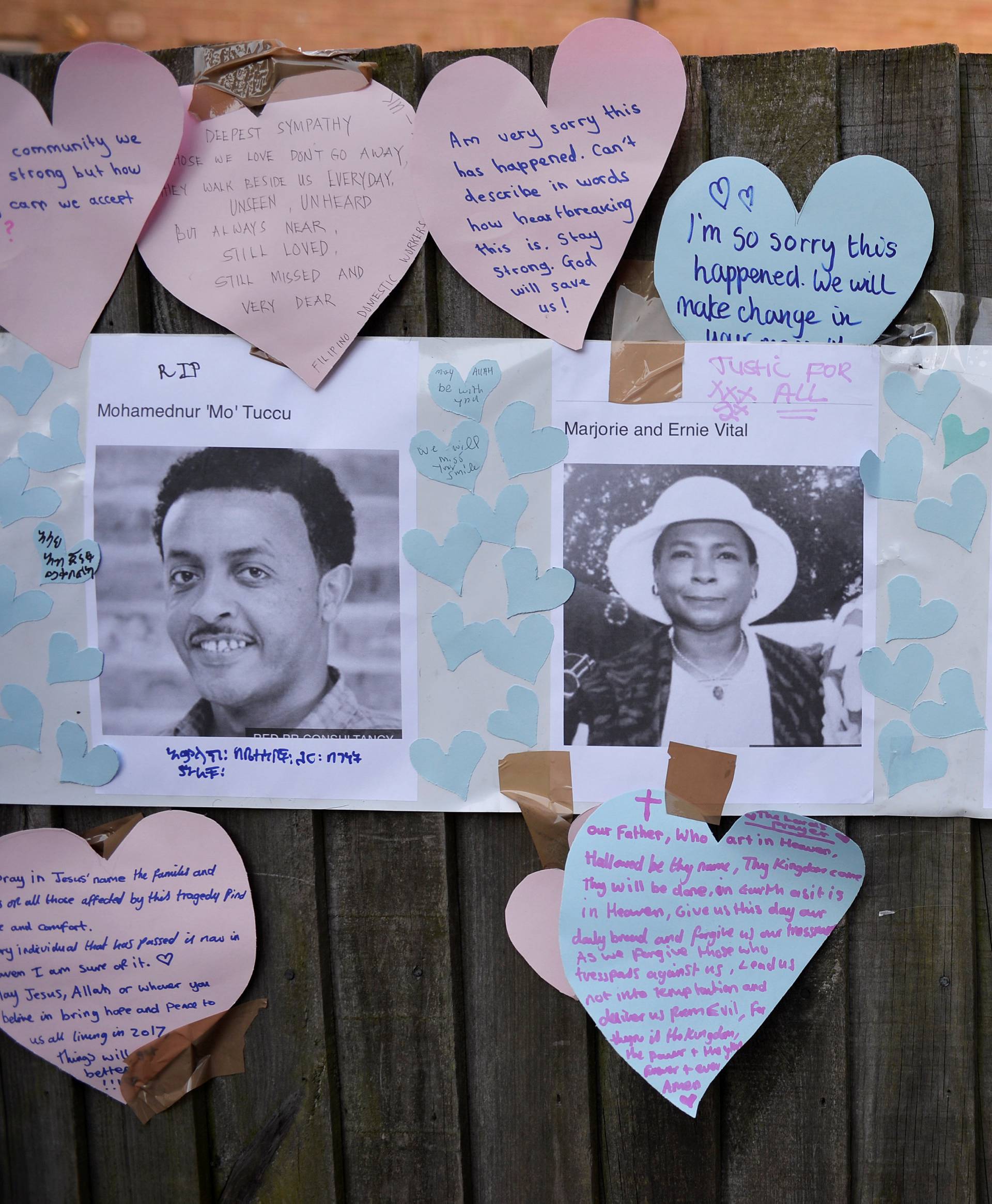 Home made posters appealing for information on people missing since the Grenfell apartment tower block caught fire are seen next to messages of sympathy in North Kensington, London