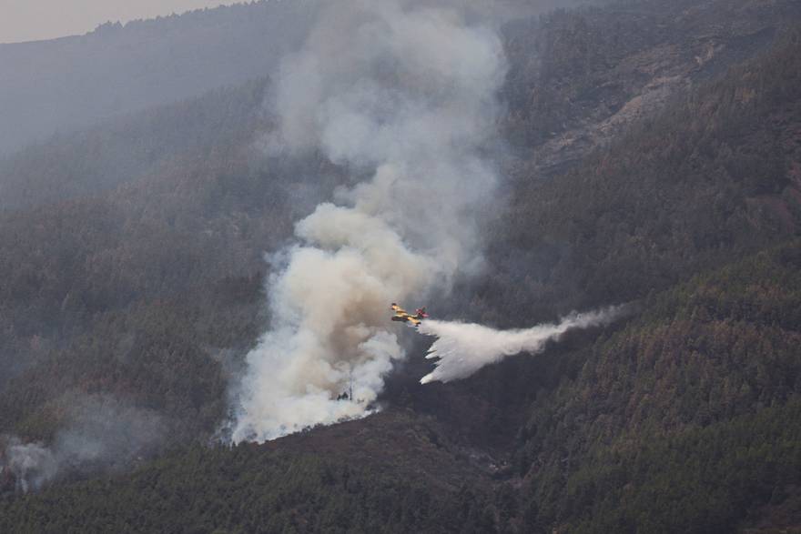Vatrogasni zrakoplov ispušta vodu iznad Guimara, dok šumski požari izmiču kontroli na otoku Tenerife