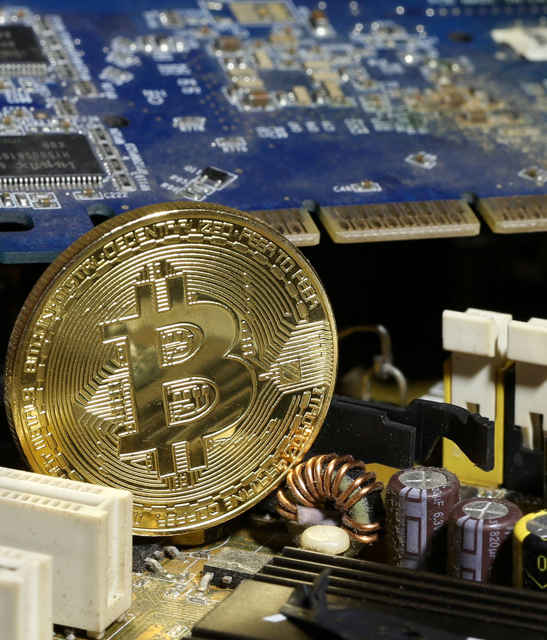 FILE PHOTO: A copy of bitcoin standing on PC motherboard is seen in this illustration picture