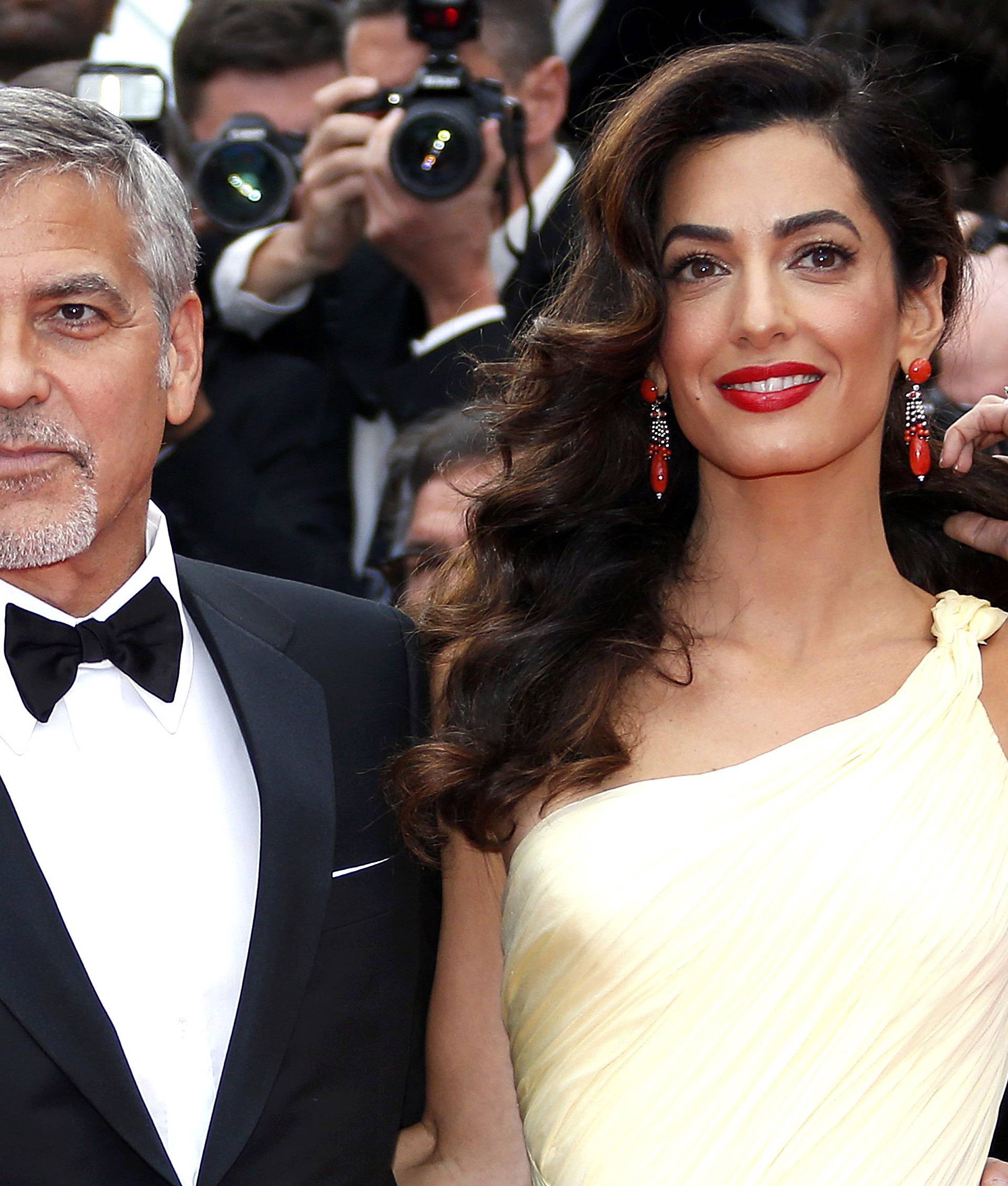 Cast member George Clooney and his wife Amal pose on the red carpet as they arrive for the screening of the film "Money Monster" out of competition during the 69th Cannes Film Festival in Cannes