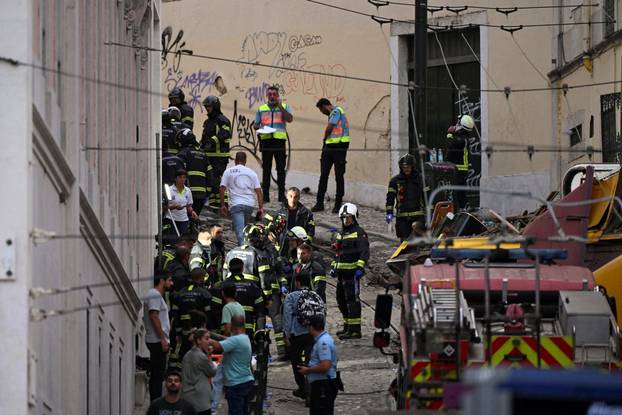 First responders work at the site of a funicular accident in Lisbon
