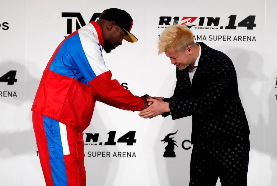 Boxer Floyd Mayweather Jr. of the U.S. shakes hands with his opponent Tenshin Nasukawa during a news conference inn Tokyo