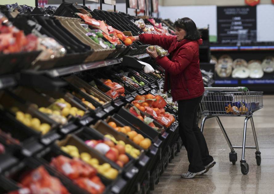 A shopper selects fruit at the Asda superstore in High Wycombe