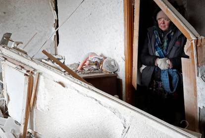 A local resident stands inside a damaged apartment in the besieged city of Mariupol