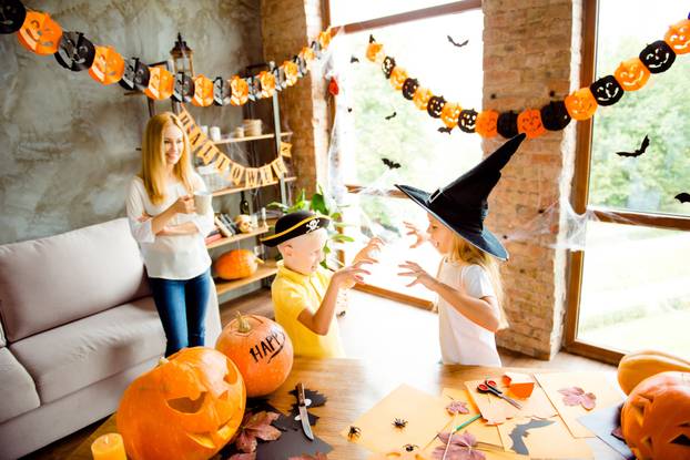 Boo! Two small blond kids are frightening each other, dressed in