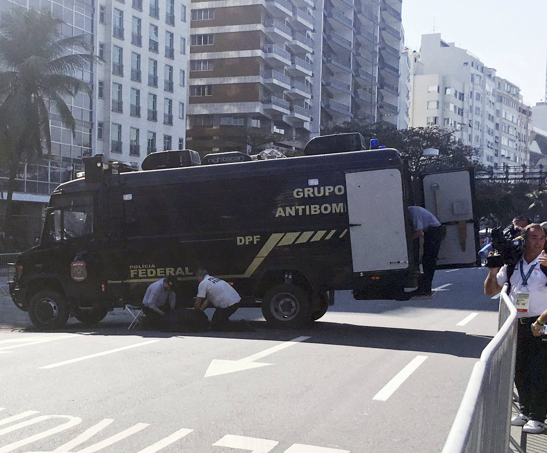 A police bomb squad inspect an unattended backpack in Copacabana Beach