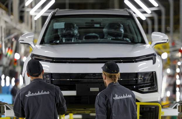 FILE PHOTO: Workers on the assembly line of the Moskvich automobile factory in Moscow