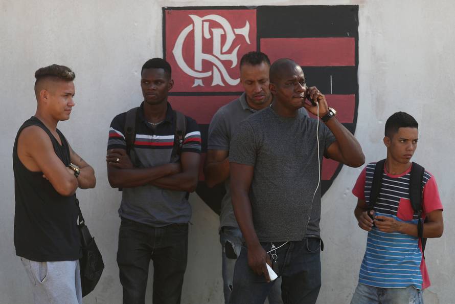 People wait for information at Flamengo training center after deadly fire in Rio de Janeiro