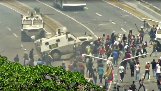 A Venezuelan National Guard vehicle ploughs into opposition demonstrators in Caracas