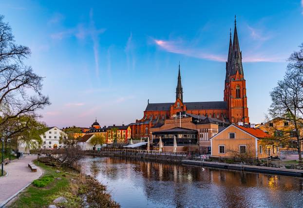 Sunset view of Uppsala cathedral reflecting on river Fyris in Sw