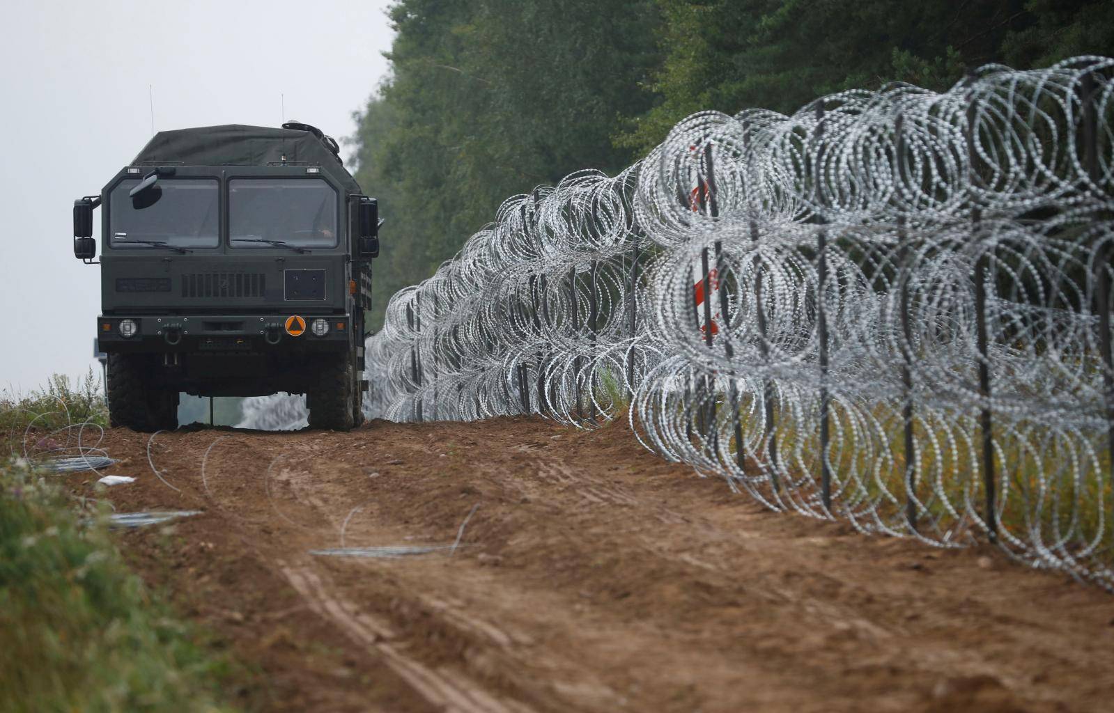 FILE PHOTO: Polish soldiers build a fence on the border between Poland and Belarus near the village of Nomiki