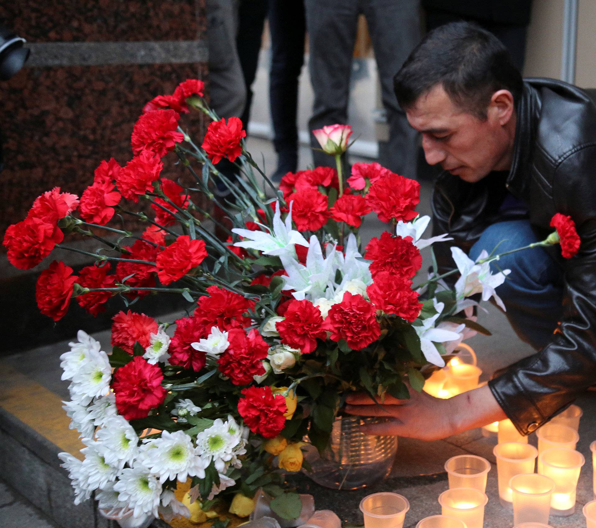 Man leaves flowers during memorial service for victims of blast in St.Petersburg metro, outside Sennaya Ploshchad metro station in St. Petersburg