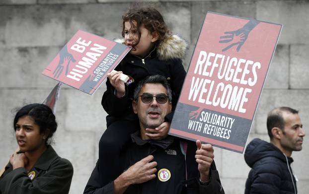 Demonstrators march to the Houses of Parliament during a protest in support of refugees, in London