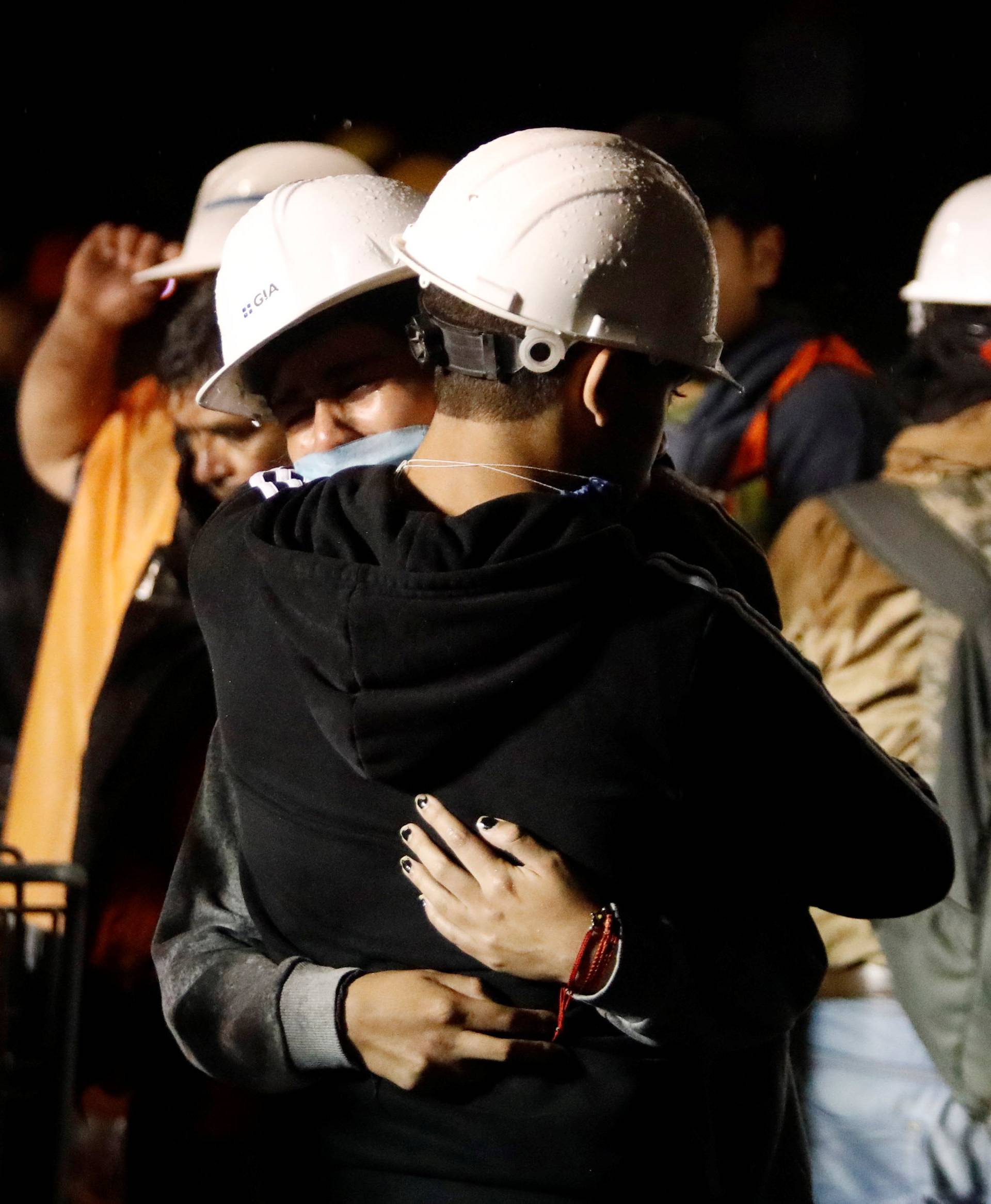 Workers hug during the search for students at Enrique Rebsamen school after an earthquake in Mexico City