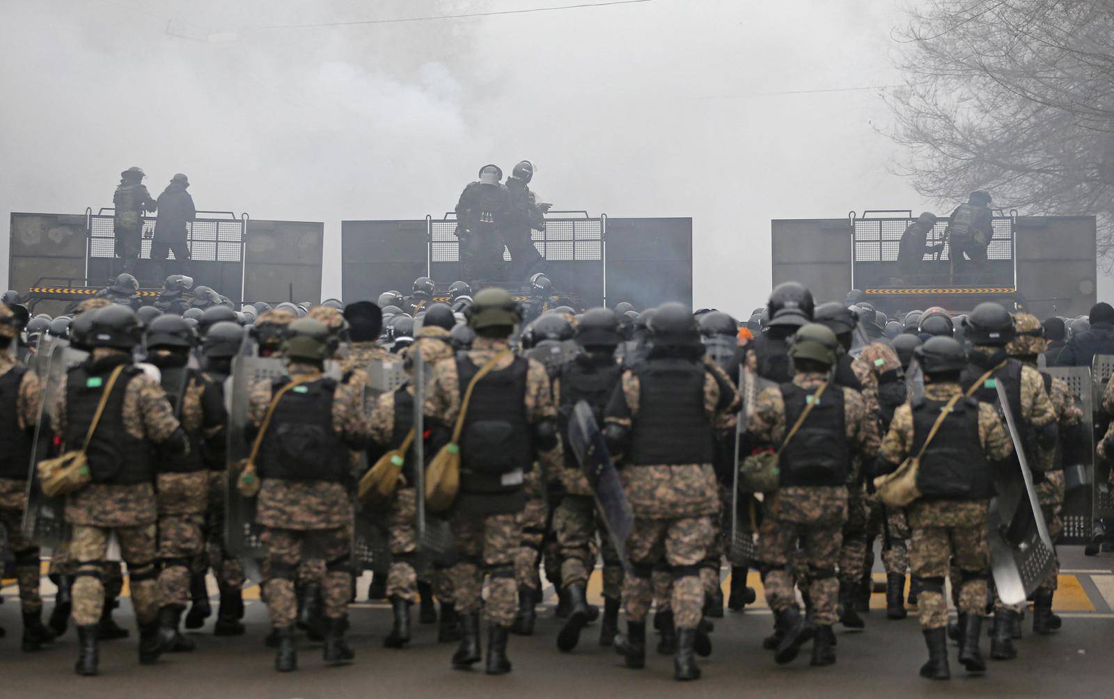 Kazakh law enforcement officers are seen on a barricade during a protest triggered by fuel price increase in Almaty
