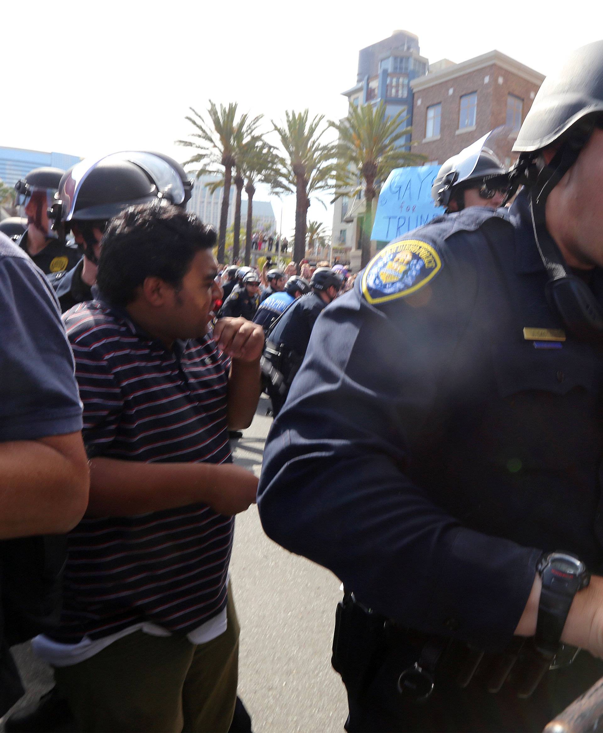 Police shove demonstrators outside a campaign event for Republican U.S. presidential candidate Donald Trump in San Diego
