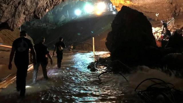 Rescue personnel walk in a cave at the Tham Luang cave complex during a mission to evacuate the remaining members of a soccer team trapped inside, in Chiang Rai