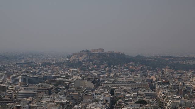 Acropolis hill with the Parthenon temple is covered with smoke from a wildfire burning the Island of Evia, in Athens