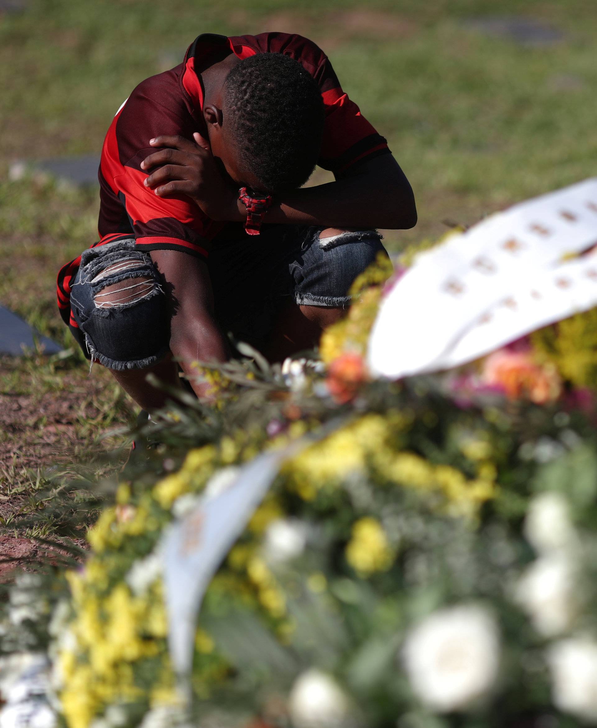 A friend of soccer player Vinicius de Barros Silva Freitas reacts during his burial, after a deadly fire at Flamengo soccer club's training center, in Volta Redonda