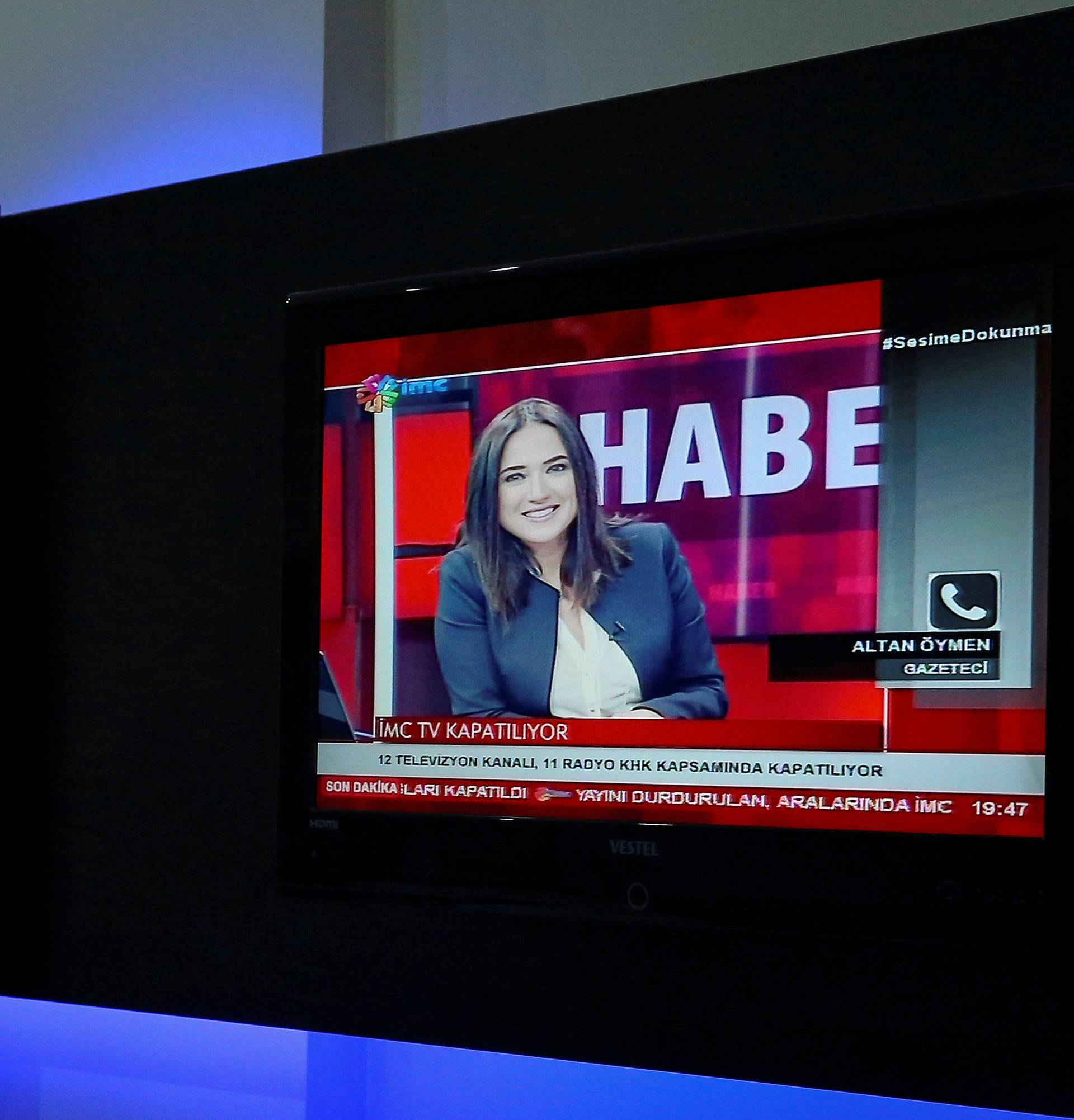 News anchor Banu Guven is seen on a screen during a news broadcast at a studio of IMC TV, a news broadcaster slated for closure, in Istanbul