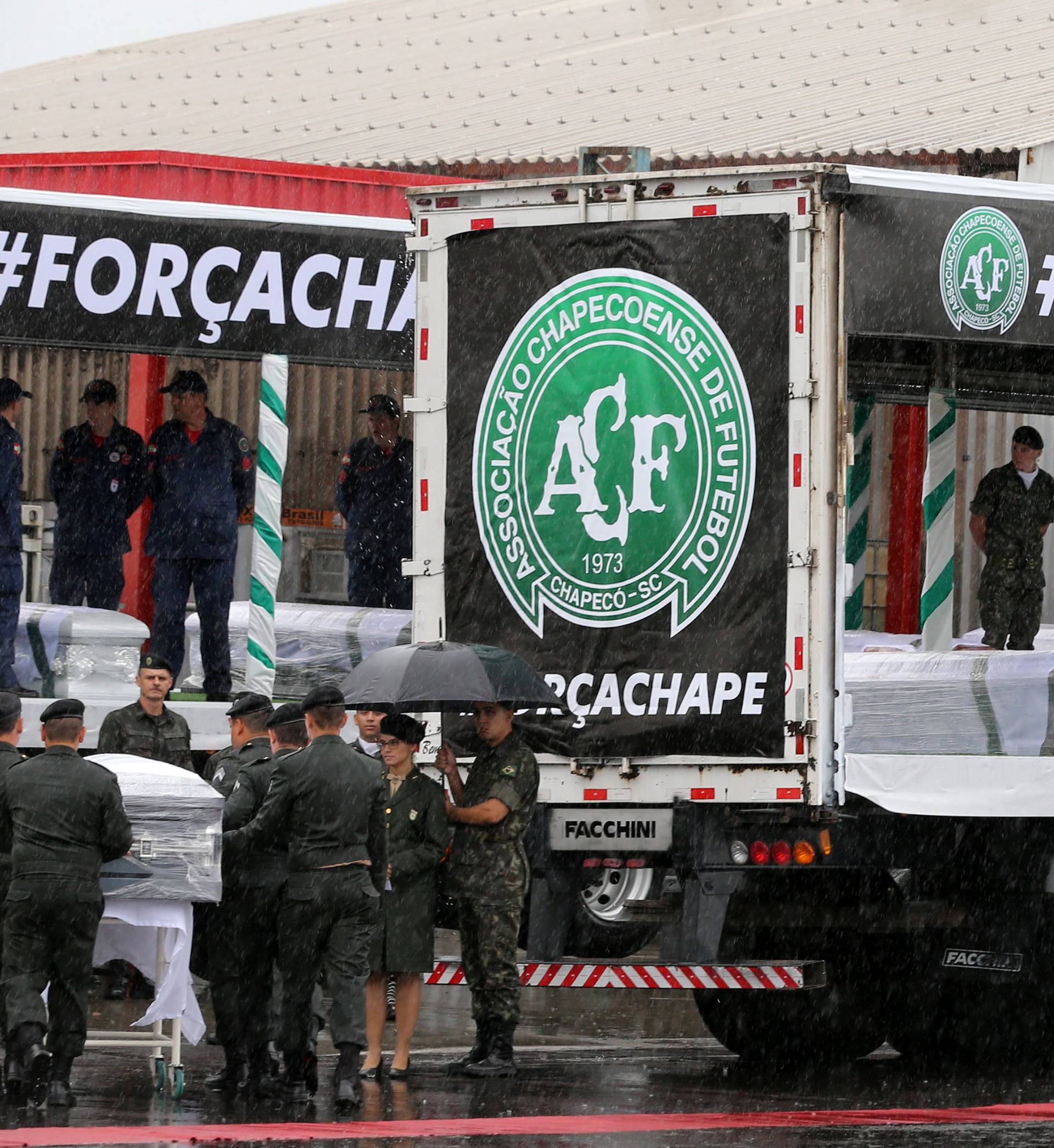 Coffins cointaining the mortal remains of victims of the plane crash in Colombia are loaded on trucks after arriving in Chapeco