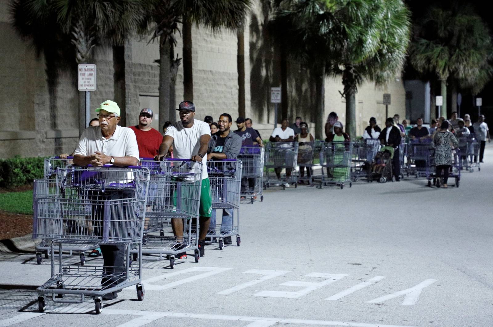 Shoppers wait in a long line for a Sam's Club store to open before sunrise, as people rushed to buy supplies ahead of the arrival of Hurricane Dorian in Kissimmee