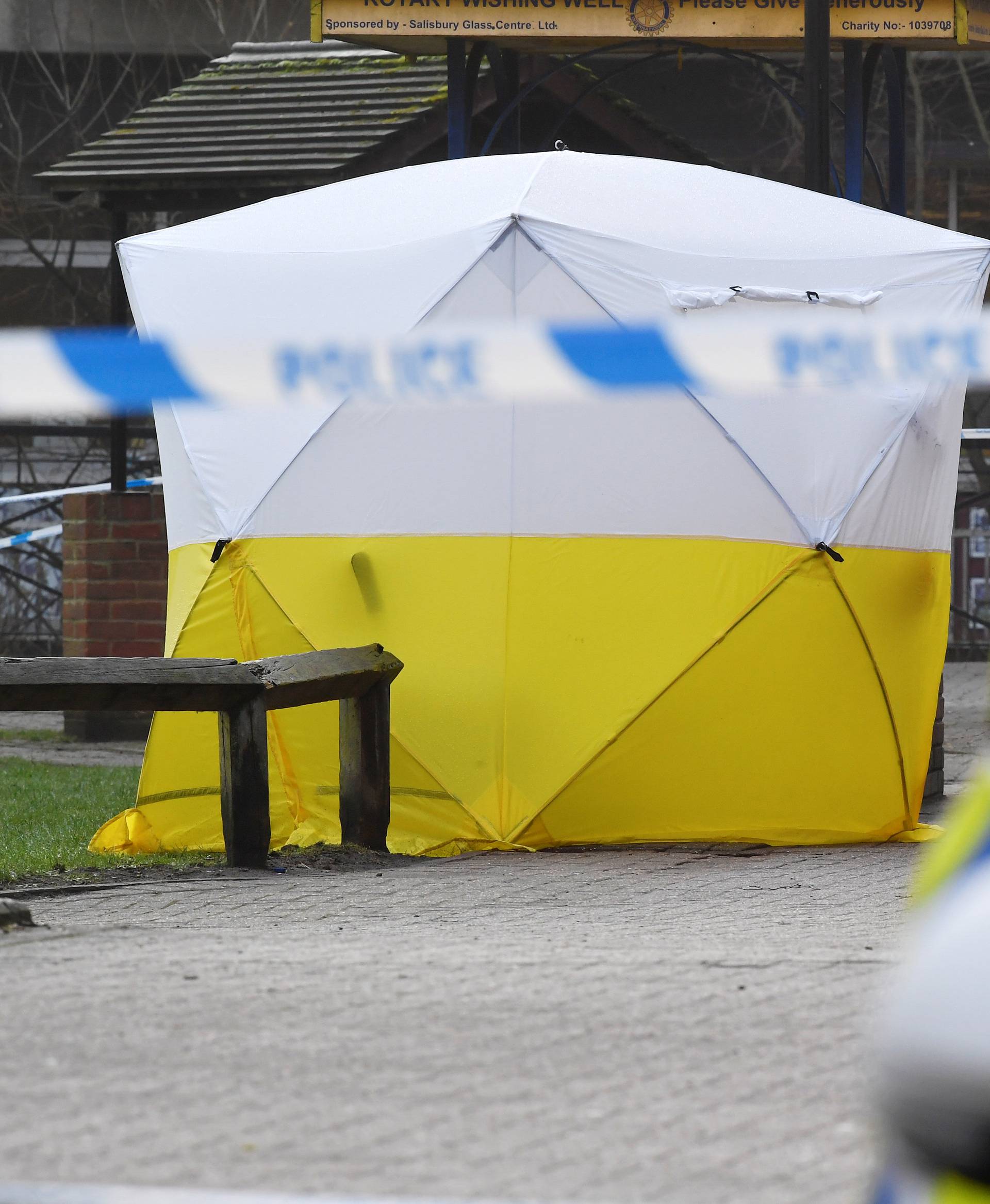 A police car is parked next to crime scene tape, as a tent covers a park bench on which former Russian inteligence officer Sergei Skripal, and a woman were found unconscious after they had been exposed to an unknown substance, in Salisbury